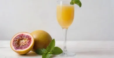 En champagne og passionsfrugt cocktail pyntet med frisk passionsfrugt og mynte på et træbord